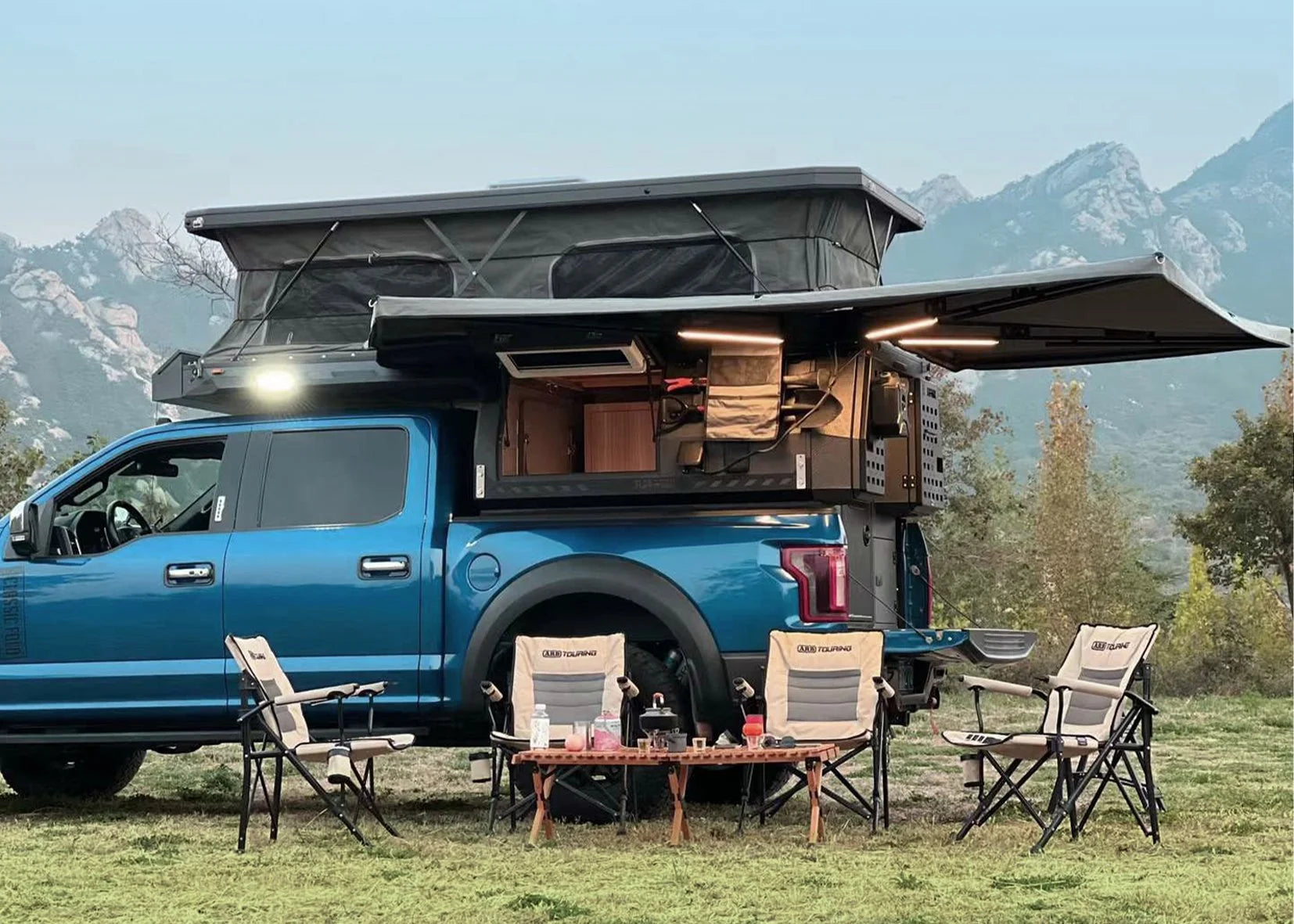 WildPORT FLAT ROAD Pickup Camper mit ausgefahrenem Aufstelldach und Markise